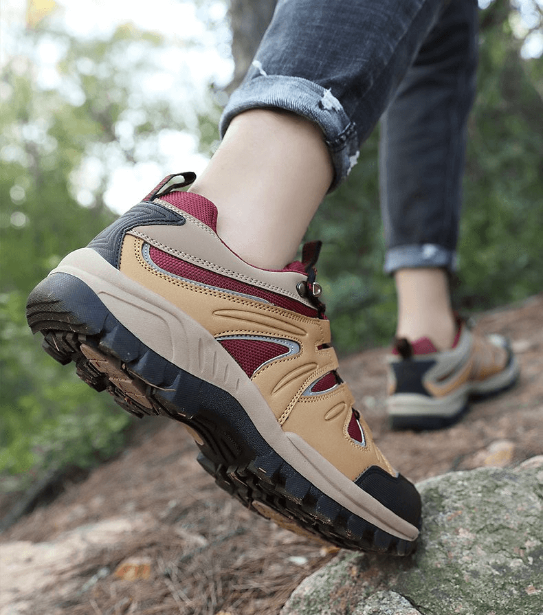 Person hiking in waterproof anti-slip men's trekking shoes, showcasing durable rubber sole on rocky terrain.