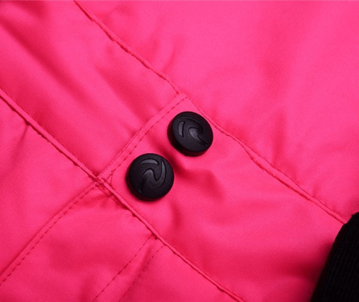 Close-up of waterproof breathable ski pants with pink fabric and black buttons, featuring high-quality stitching detail.
