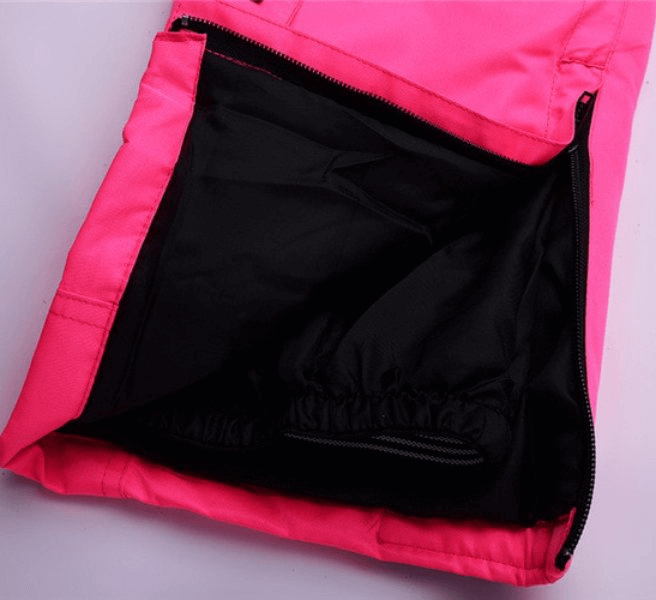 Close-up of the waterproof breathable ski pants with zipper fly, showcasing the pink and black nylon-polyester blend material.