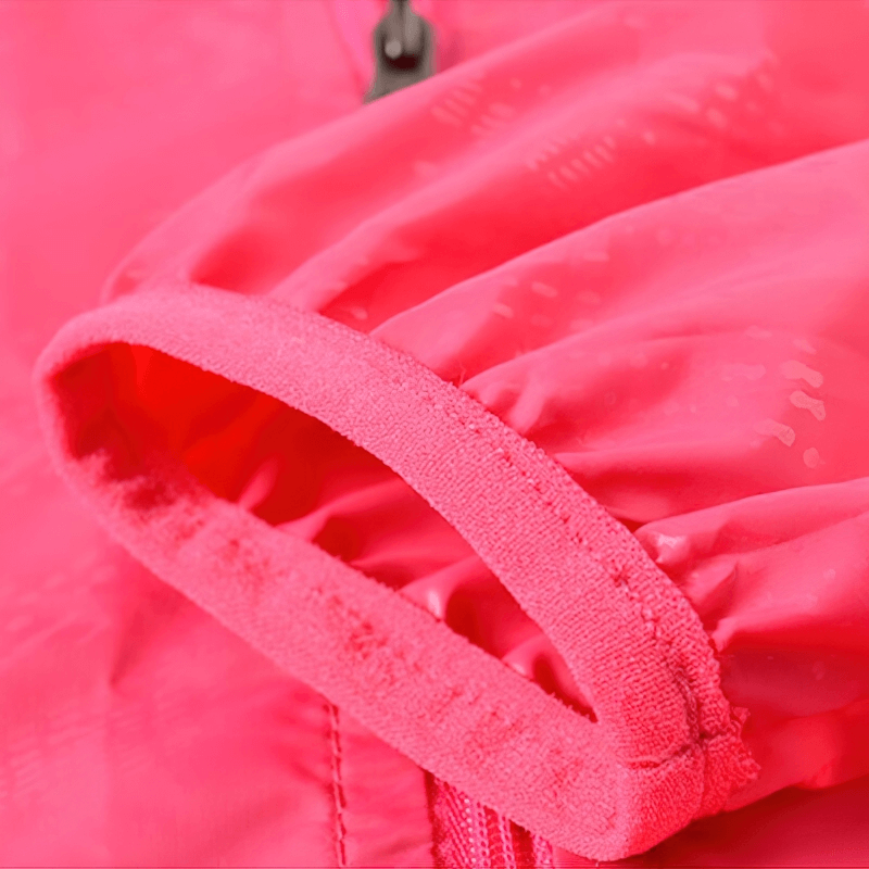 Close-up of bright pink waterproof hooded jacket sleeve, showcasing durable nylon material and stitching details.
