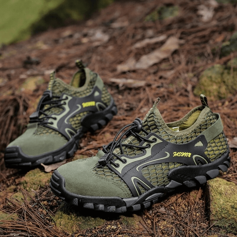 Green waterproof non-slip climbing sneakers for men placed on a woodland floor, showcasing a rugged rubber sole and stylish patchwork design.