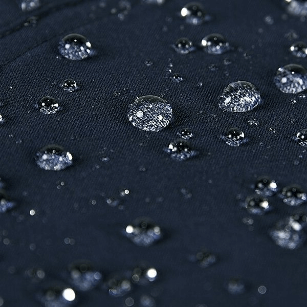 Close-up of water droplets on waterproof breathable pants fabric, showcasing the fabric's durability for outdoor activities.