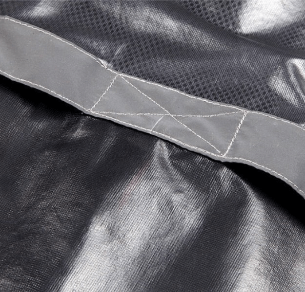 Close-up of waterproof reflective bike rain cover fabric, showcasing durable polyester material and reflective strip for visibility.