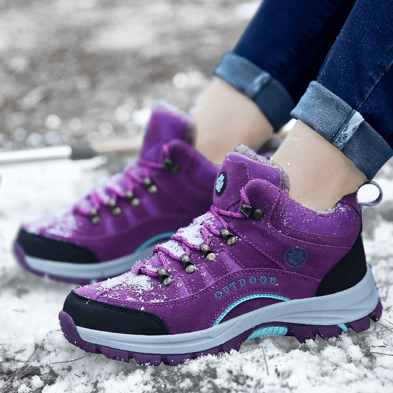 Purple waterproof snow trekking boots with anti-collision toe on snowy ground, perfect for winter hiking and outdoor adventure.