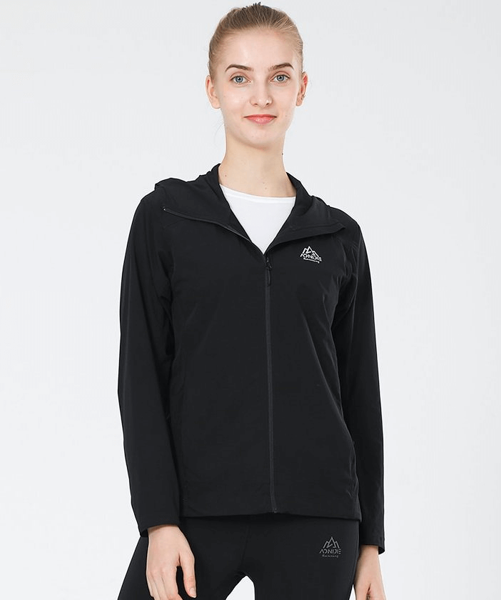 Woman wearing black waterproof sports jacket with hood and zipper, ideal for running, showcasing lightweight and breathable design.