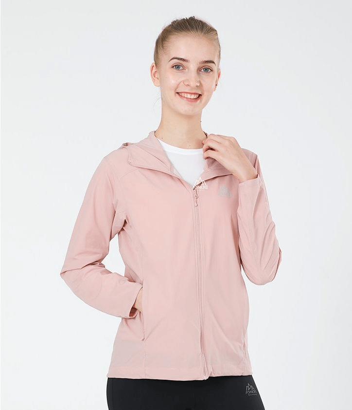 Smiling woman wearing a pink waterproof sports jacket with hood and zipper, for running and outdoor activities.