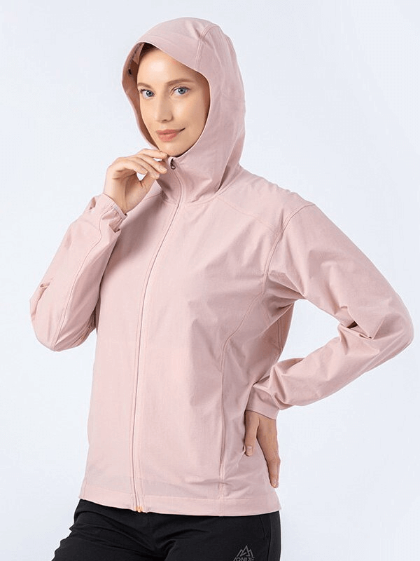 Woman wearing a pink waterproof sports jacket with hood and zipper, ideal for running and outdoor activities, SF0897 model.