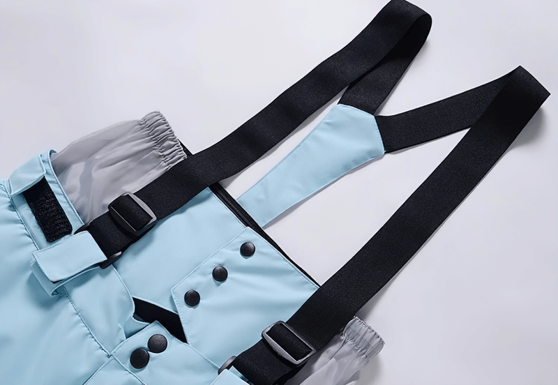 Light blue waterproof snowboarding trousers with adjustable black suspenders, featuring button details and waist protection.