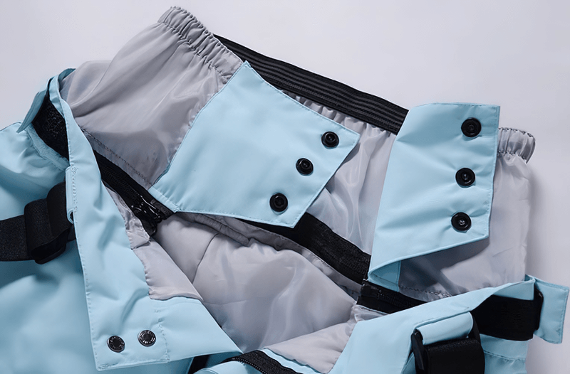 Close-up of waterproof warm snowboarding trousers with adjustable waist protection in blue, showcasing buttoned design.