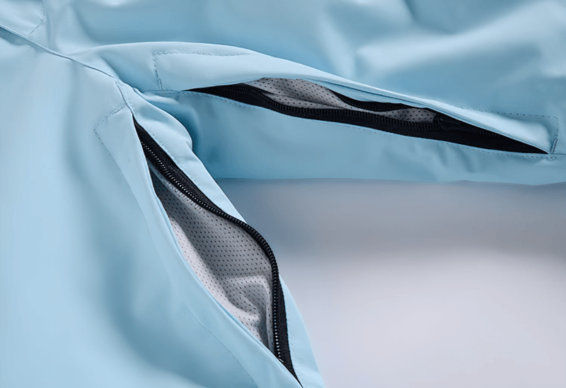 Close-up of blue waterproof snowboarding trousers with open zippered vents, showing breathable interior fabric.
