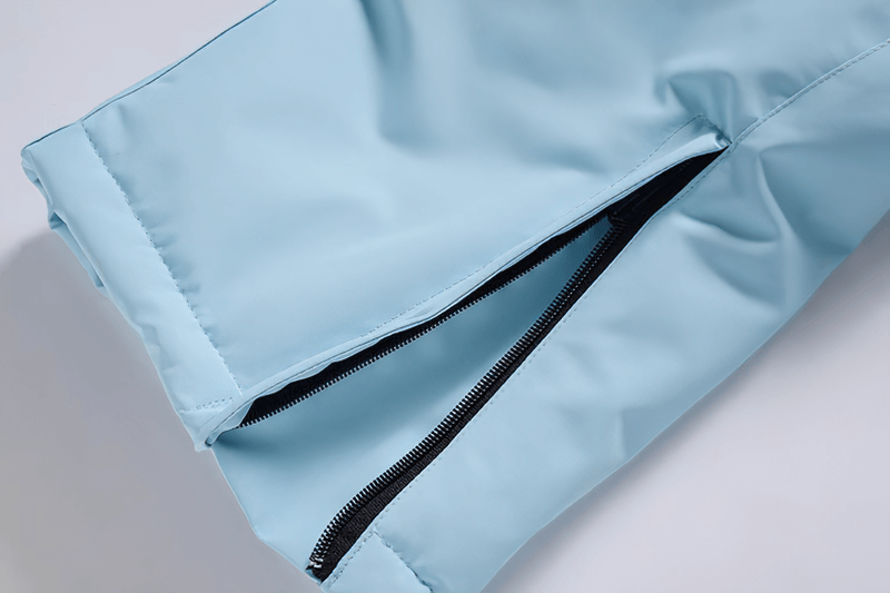 Close-up of waterproof warm snowboarding trousers with zipper fly and waist protection in light blue, ideal for extreme conditions.