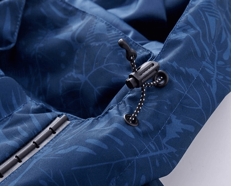Close-up of a blue waterproof windproof quick dry jacket showing adjustable drawstring and detailed stitching, ideal for outdoor use.