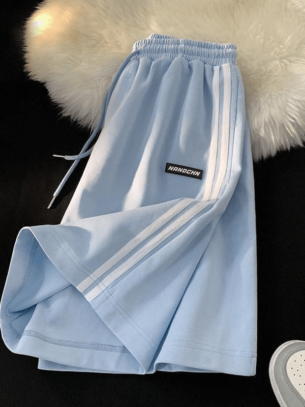 Light blue wide sport casual women's shorts with elastic waistband and white stripes for athletic comfort.