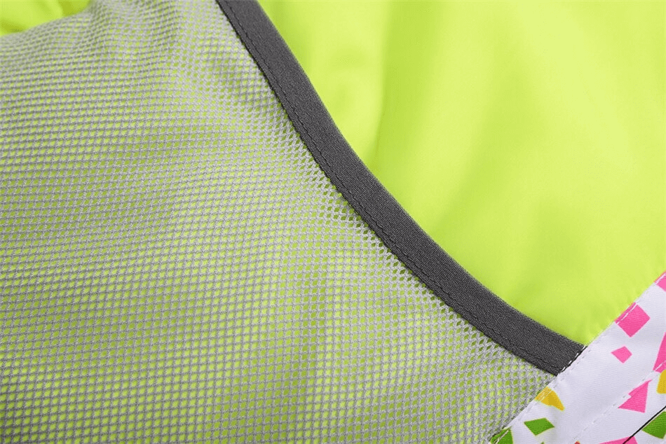 Close-up of a multicolor skiing jacket fabric with vibrant neon and geometric patterns.