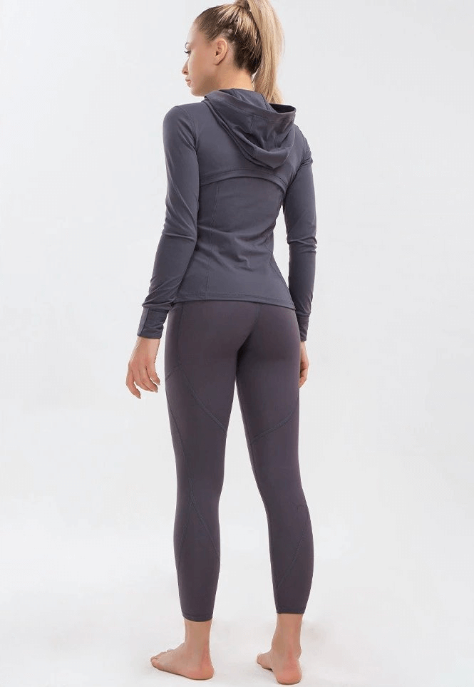 Back view of woman in long-sleeve quick-drying sports shirt and leggings for yoga