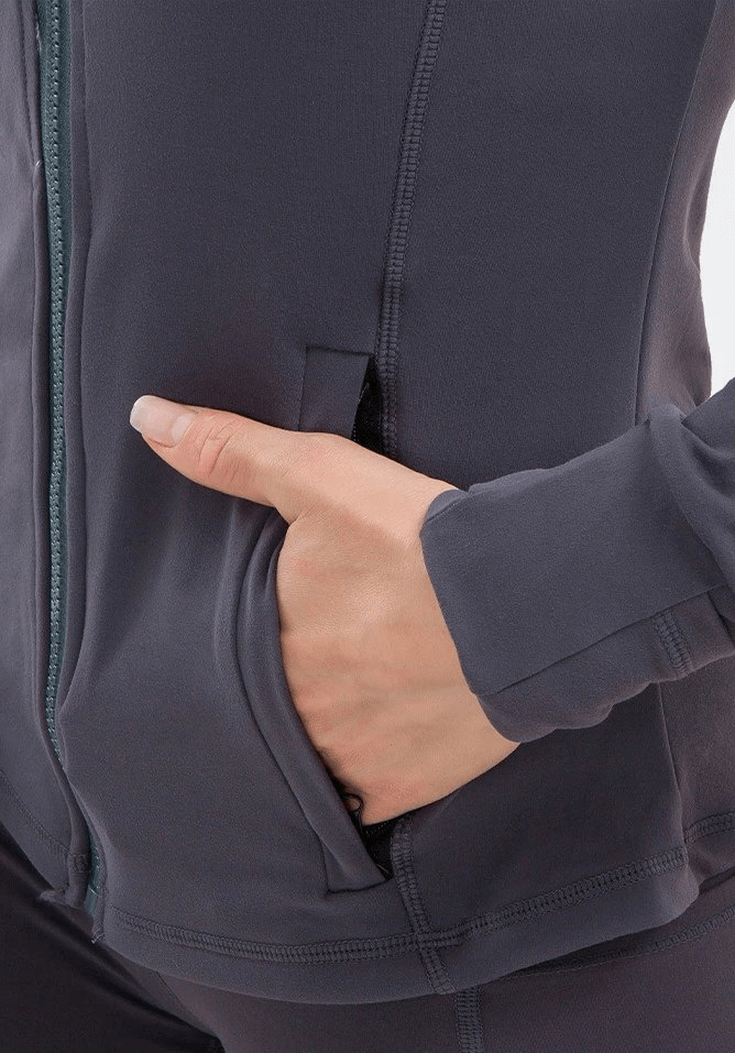 Close-up of a woman in a long-sleeve quick-drying sports shirt with her hand in the side pocket, ideal for yoga and active wear.