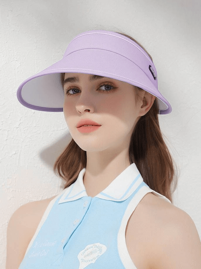 Woman wearing a purple foldable sun visor hat with adjustable fit, providing sun protection. Ideal for outdoor activities.