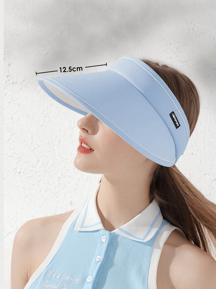 Woman wearing stylish blue foldable sun hat visor with sun protection, adjustable fit, perfect for outdoor activities.
