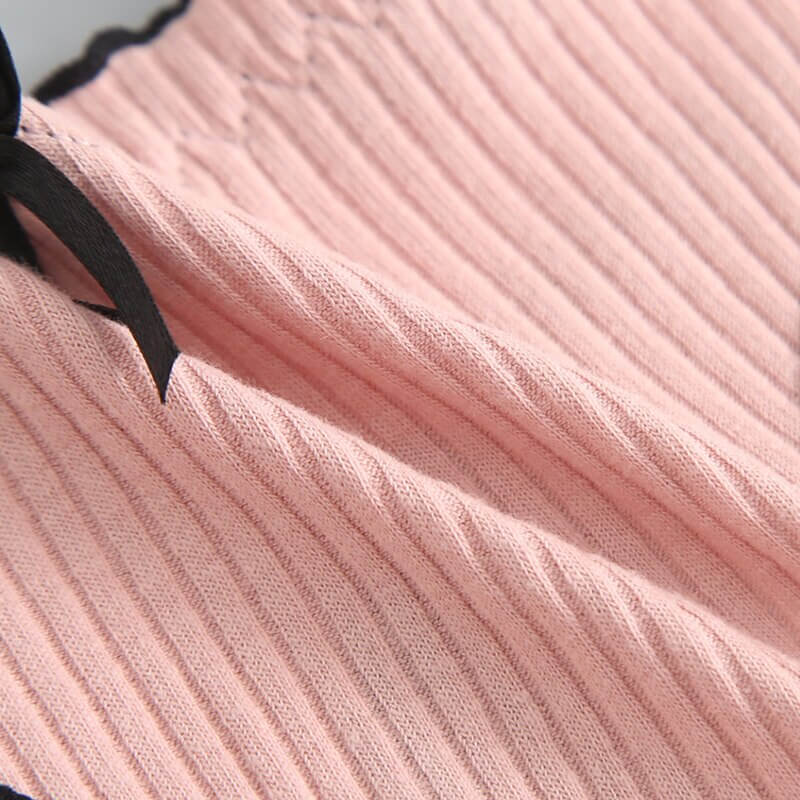 Close-up of pink ribbed cotton fabric with black bow on women's low-rise T-back G-string. Soft, comfortable, and stylish lingerie.