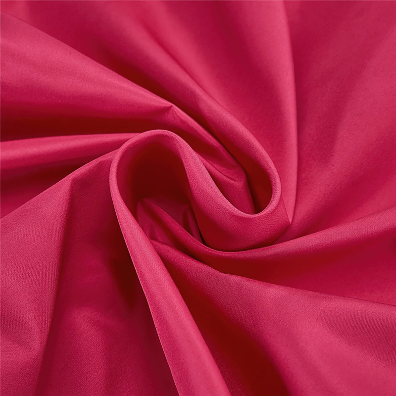 Close-up of vibrant red polyester fabric used in women's windproof cycling vest, showcasing smooth texture and quality.