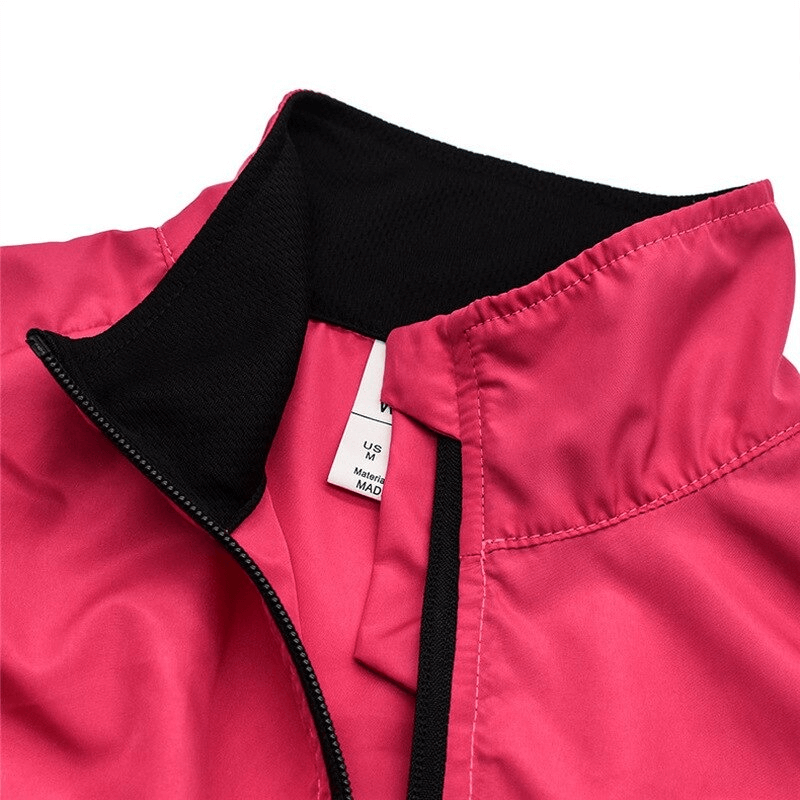 Close-up of red women's cycling windproof vest with black collar, featuring breathable polyester fabric and reflective elements.