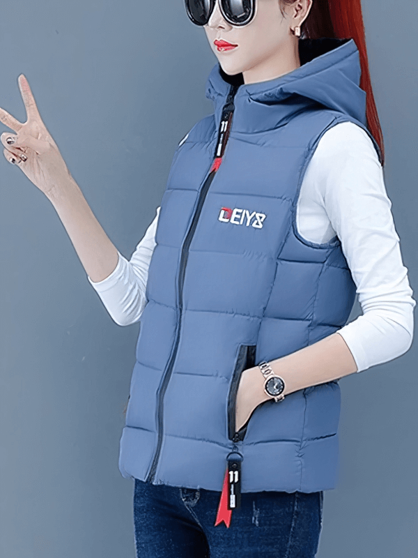 Woman wearing a blue hooded down vest with zipper pockets, stylish and warm for cooler weather.