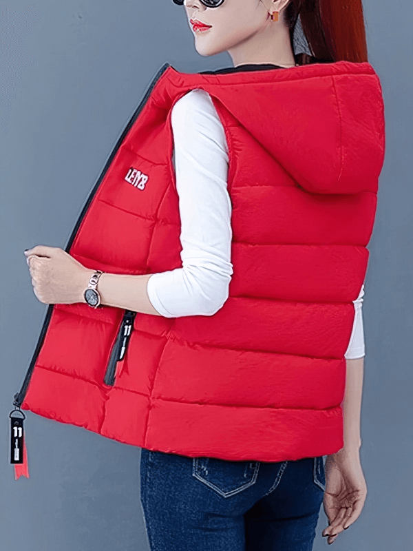 Woman wearing a red down vest with zipper pockets and hood, perfect for staying warm and stylish in cooler temperatures.