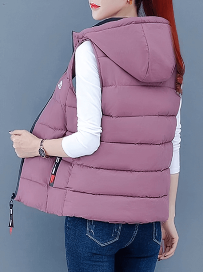 Stylish women's hooded down vest in mauve with zipper pockets, perfect for cooler days, combines fashion and function.