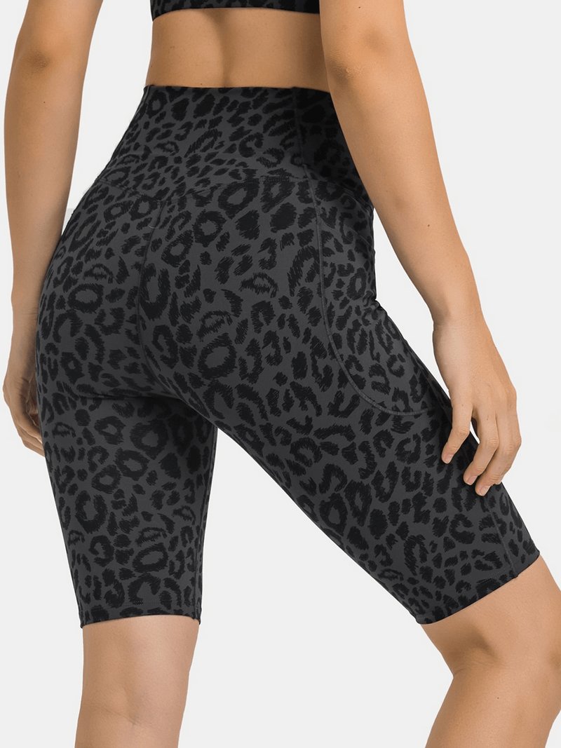 Stylish women's elastic yoga shorts with leopard print, cross waist, and two deep pockets, perfect for comfort and functionality.