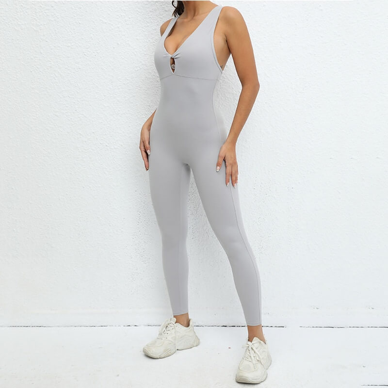 Woman wearing a sleeveless fitness jumpsuit with asymmetrical back, made from nylon and spandex, ideal for yoga and workouts.
