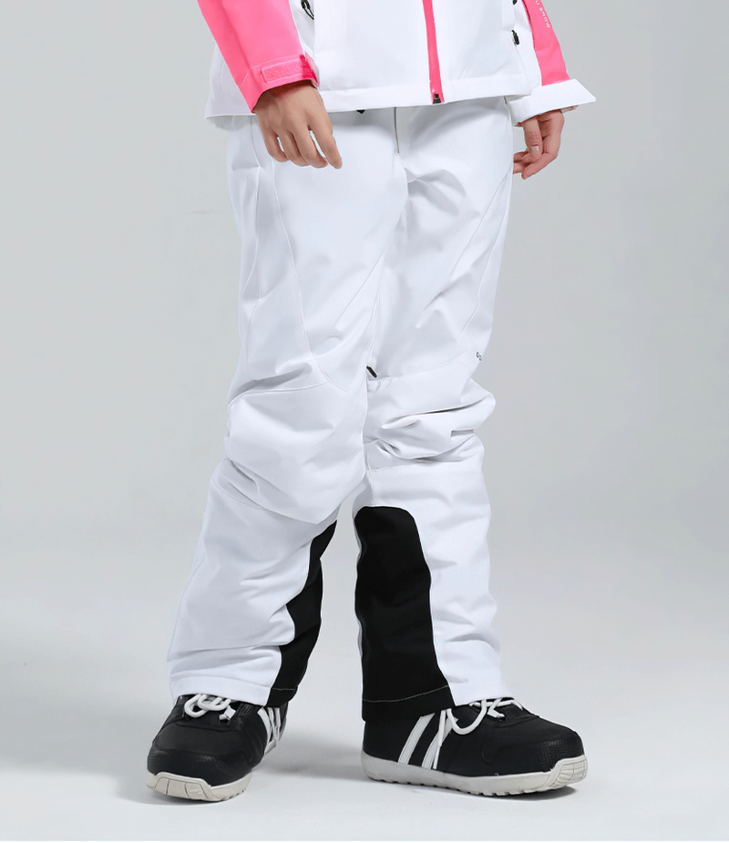 Woman wearing white high waist snow pants with waterproof zipper pockets and black knee accents, perfect for skiing or winter sports.