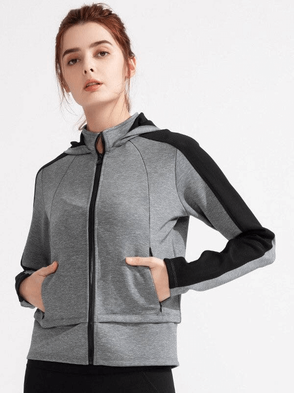 Grey women's hooded sweatshirt with zipper and thumb holes, perfect for workouts. Made from stretchy, breathable nylon and spandex. SF0072