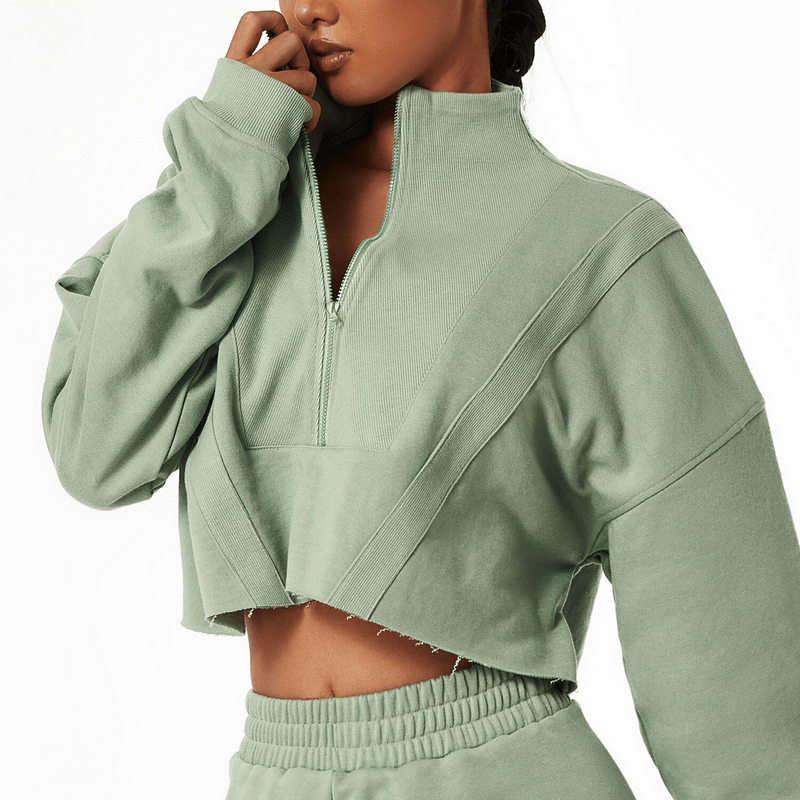 Woman wearing a stylish, loose cropped sweatshirt, perfect for yoga and casual outings, in soft green cotton for breathability and comfort.