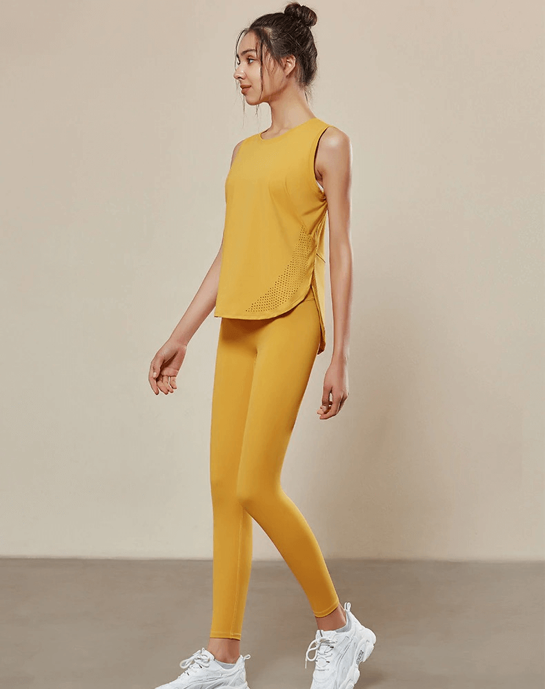Woman wearing a yellow sleeveless yoga top and leggings, highlighting breathable mesh design for optimal performance.