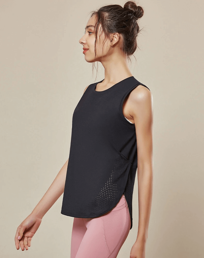 Woman wearing a black loose mesh breathable sleeveless yoga top, perfect for cool, comfortable workouts. Ideal for female yoga enthusiasts.