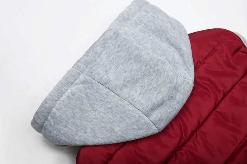 Close-up of a women's hooded red vest showing gray hood and quilted design, made from cotton and polyester for warmth and comfort.