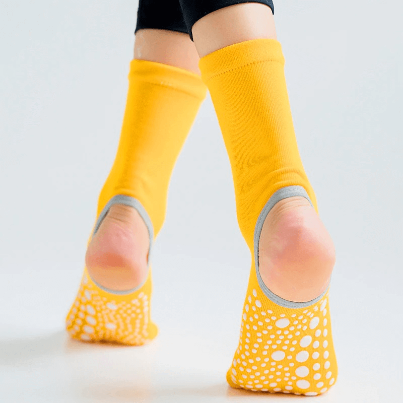 Yellow open toe non-slip yoga socks with silicone soles for enhanced grip and stability during exercise activities.