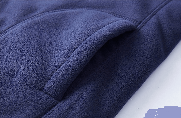 Close-up of navy blue reversible fleece jacket pocket showcasing soft fabric texture.