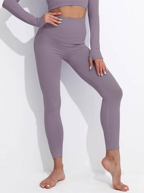 Woman wearing seamless high waist yoga leggings in gray, made of nylon and spandex, showcasing comfort and flexibility for active wear.