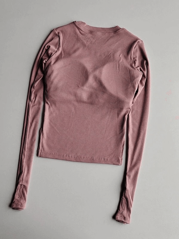 Women's seamless long-sleeve yoga shirt in pink, perfect for flexibility and comfort during workouts. Nylon and spandex blend for breathability.