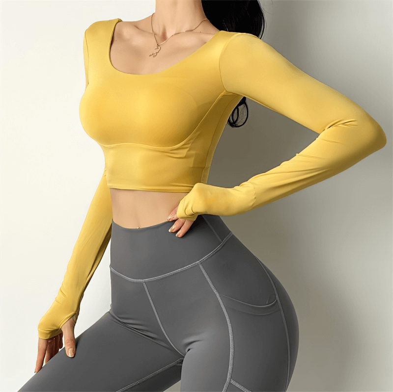 Yellow long sleeve sports top for women, perfect for yoga and running. High elasticity and breathable fabric. Model wearing grey leggings.