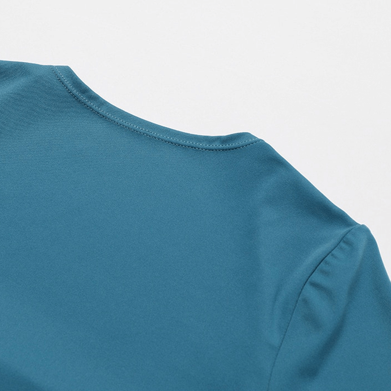 Close-up of the neckline on a teal women's short one-piece sports suit, showcasing smooth nylon-spandex fabric.