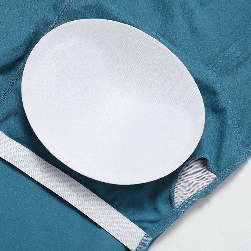 Close-up of women's sports suit with removable pad for comfort, showcasing breathable fabric and sleek design in vibrant teal.