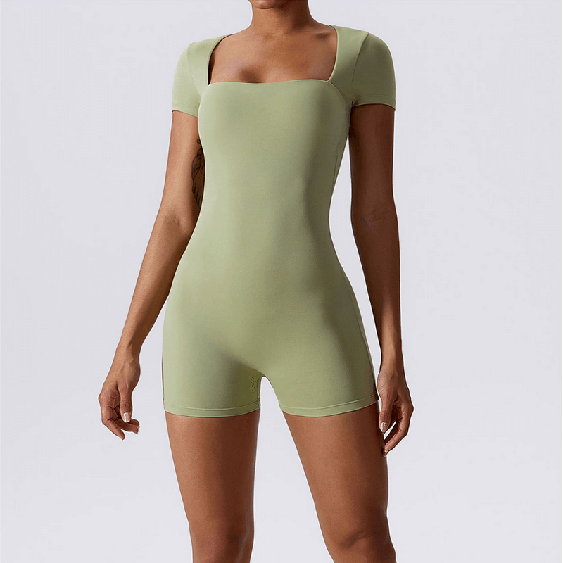 Women's green short one-piece sports suit for training and fitness, made from nylon and spandex, featuring breathable and quick-dry fabric.