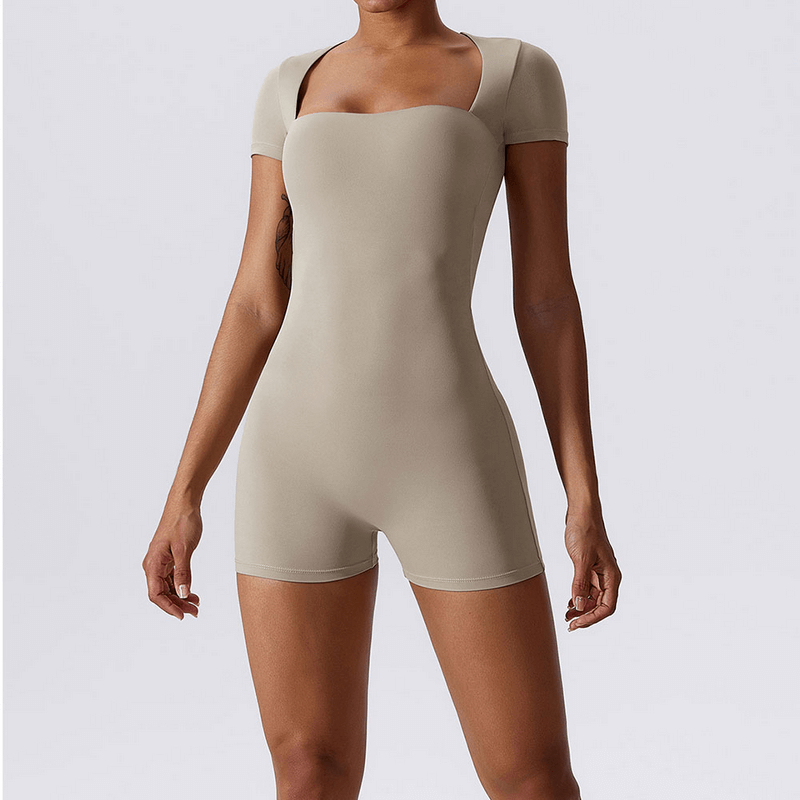 Women's one-piece sports suit in beige, short sleeves, ideal for fitness training with breathable and quick-dry technology.