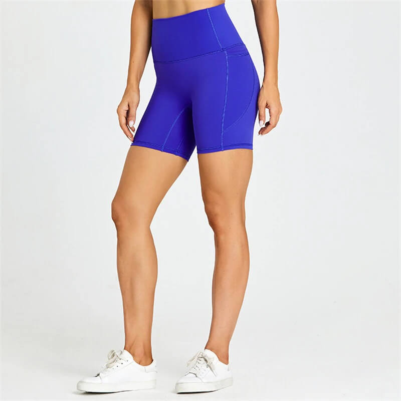 Women's solid color tight shorts with pockets, showcasing breathable nylon-spandex blend, perfect for workouts. Model in blue. SF0407