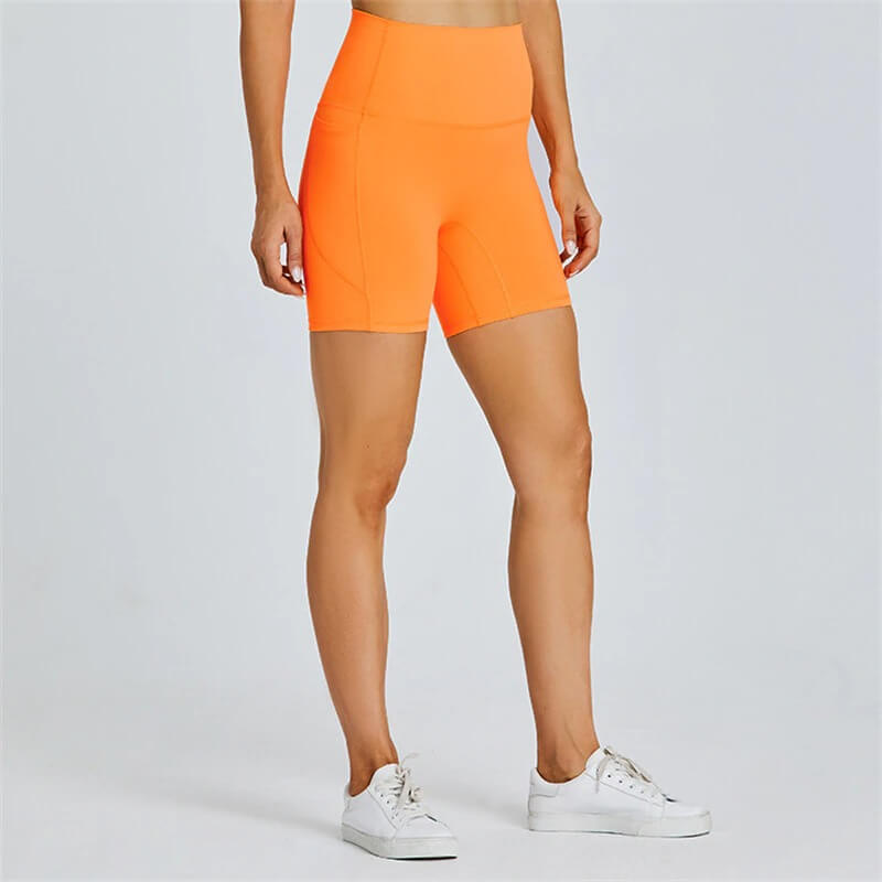 Bright orange women's short tight solid color workout shorts with pockets, designed for mobility and comfort, nylon-spandex blend.