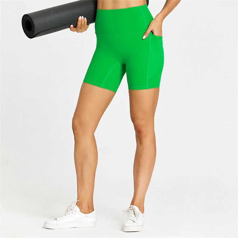 Women's short tight solid color shorts with pockets for workouts, shown in green, featuring nylon-spandex blend for comfort and support.