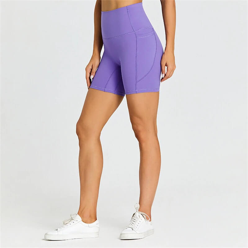 Women's short tight solid color purple workout shorts with pockets, providing comfort and flexibility, perfect for active lifestyles.