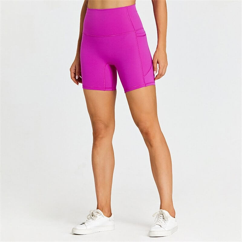 Women's short tight solid color workout shorts with pockets in vibrant purple, offering comfort and mobility for active lifestyles.